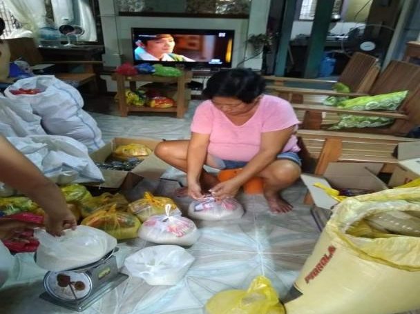 Une Philippine préparant des colis alimentaire Covid-19